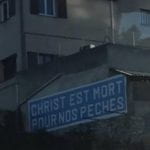 Street sign in French saying, "Christ est mort pour nos peches."