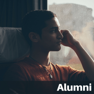 Text on image "Alumni": Male student looking pensively out train window