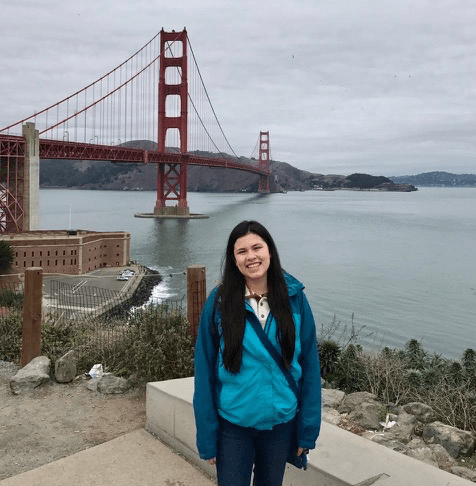Julia in front of water and bridge