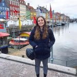 Talia standing in front of colorful houses in Copenhagen