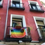 Red building with pride flag hanging from balcony