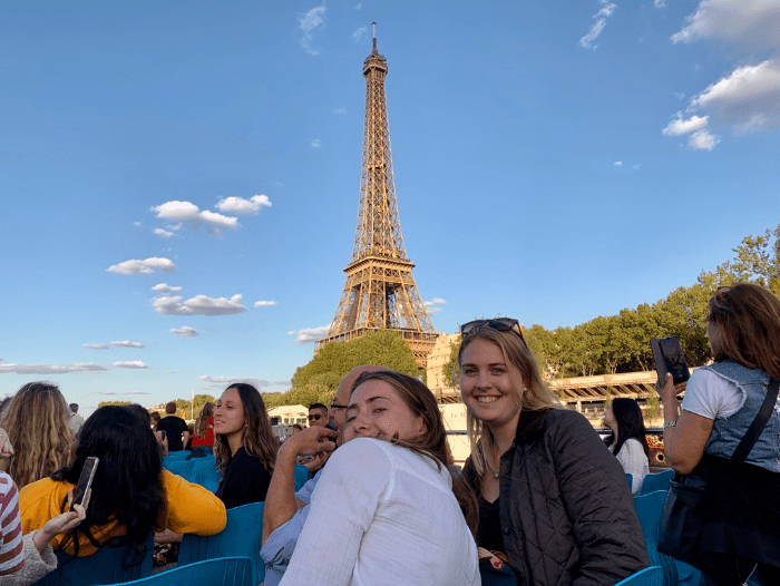 Two girls on a boat in front of Eiffel tower on Seine River
