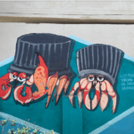 This mural depicts crabs with to-go containers in the place of their shells. The caption says, “plastics take thousands of years to degrade.”
