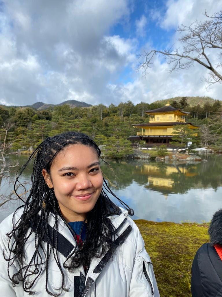 Mia smiles while posing in front of a temple