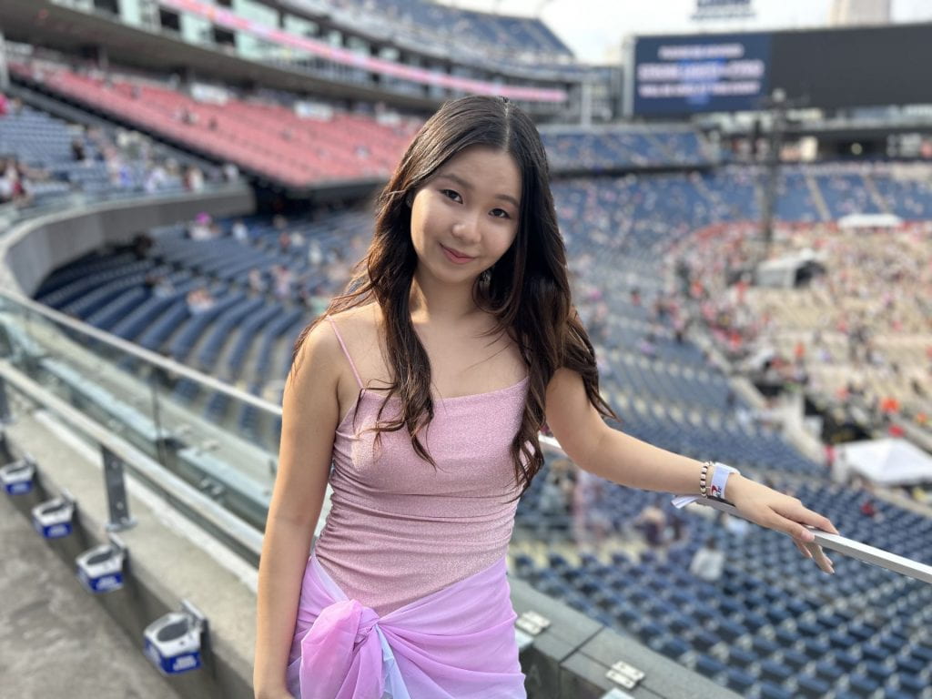 Woohyun smiles posing in a concert stadium