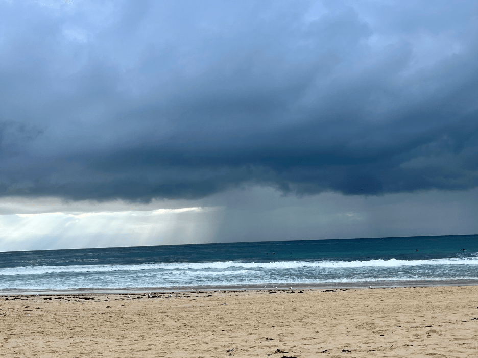 A beach with waves and clouds