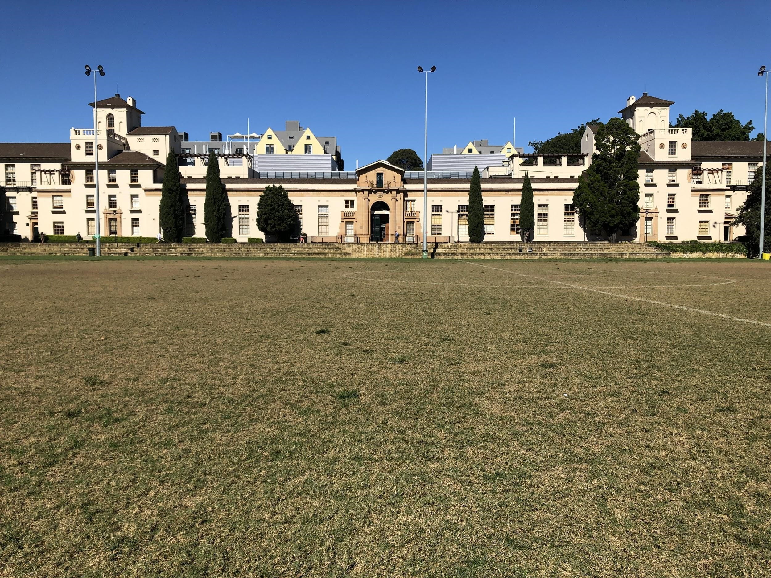 Long beige building with large grassy lawn in front