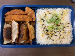 A bento box with gyoza and white rice