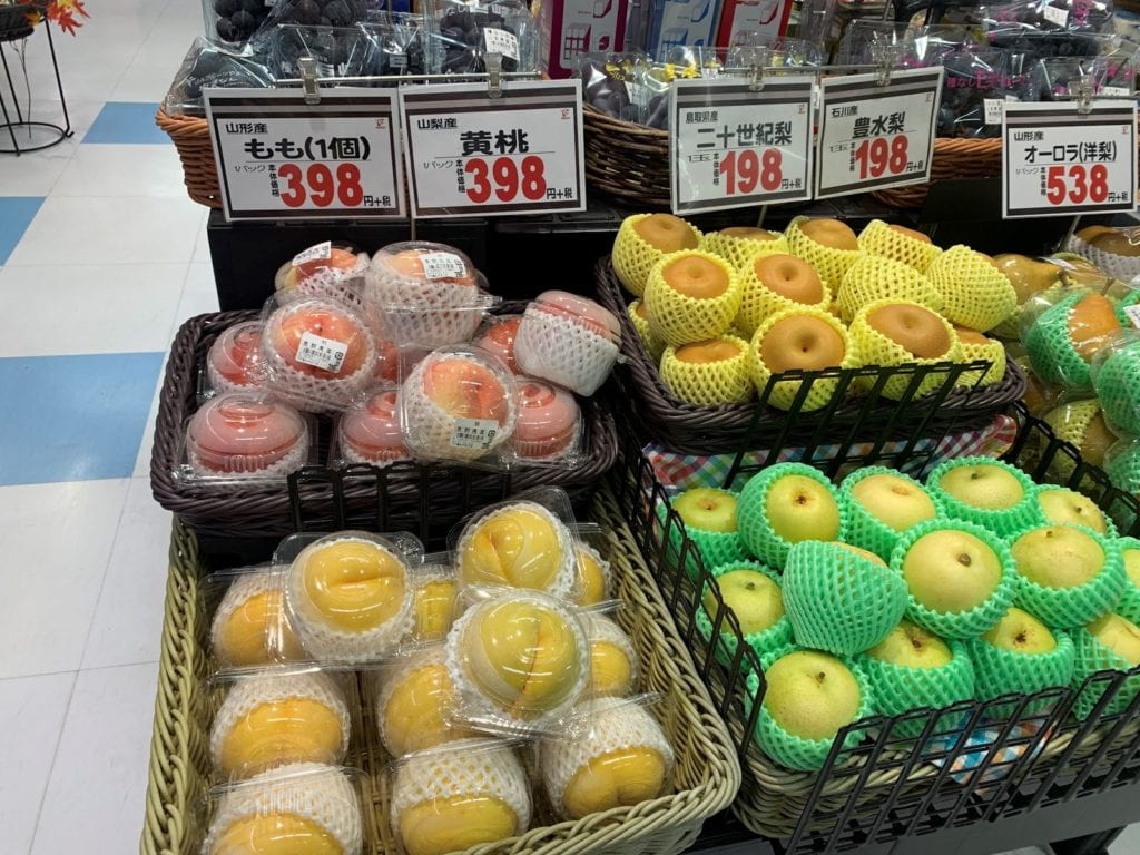 Individually wrapped peaches and other fruits in a grocery store
