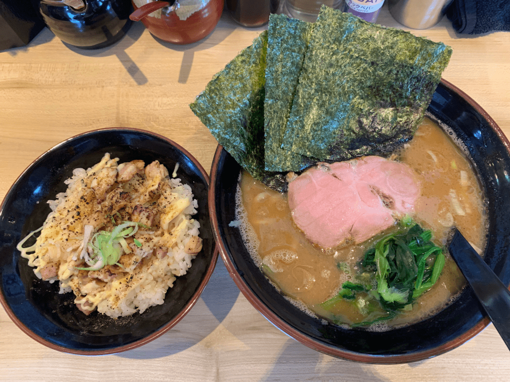 A large bowl of ramen and smaller bowl of noodles