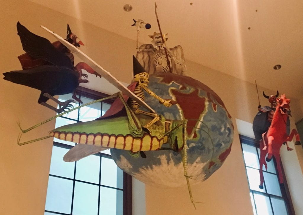 A hanging display depicting various creatures around a globe