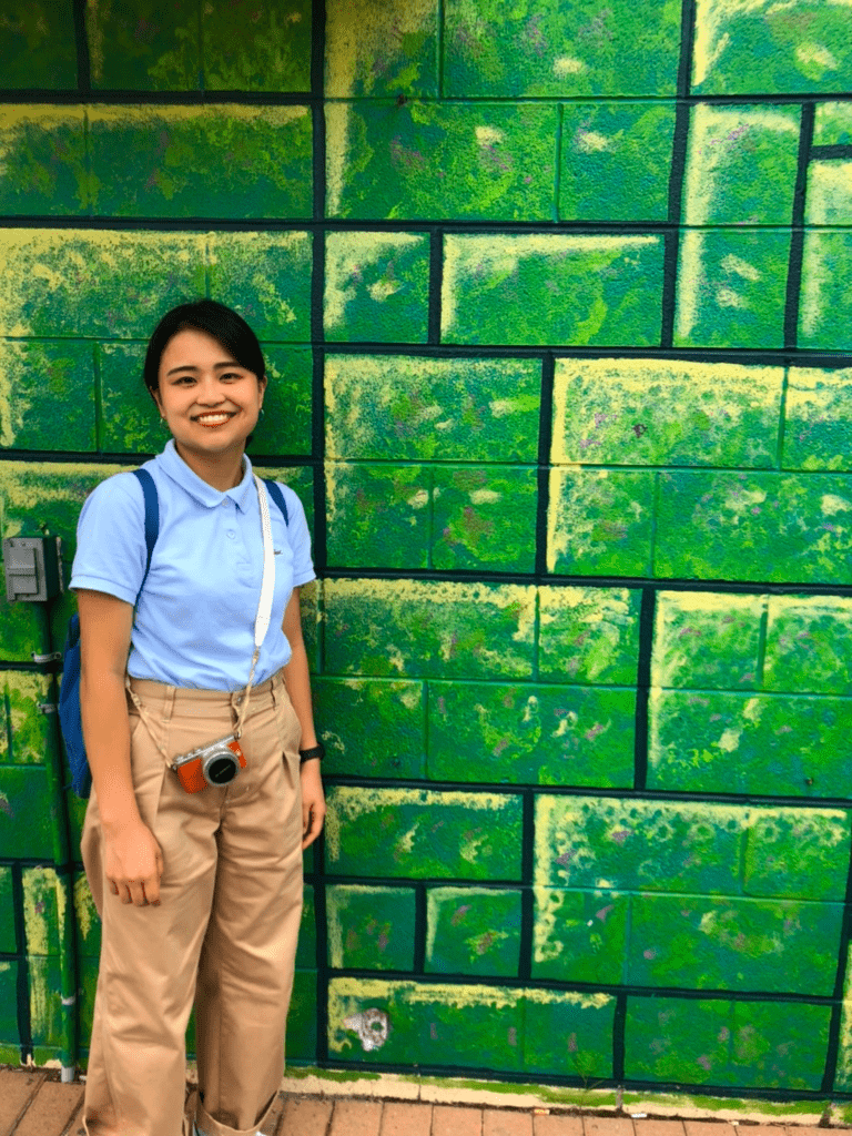 Doshisha student, Arisa Yoshimura, standing in front of a green wall