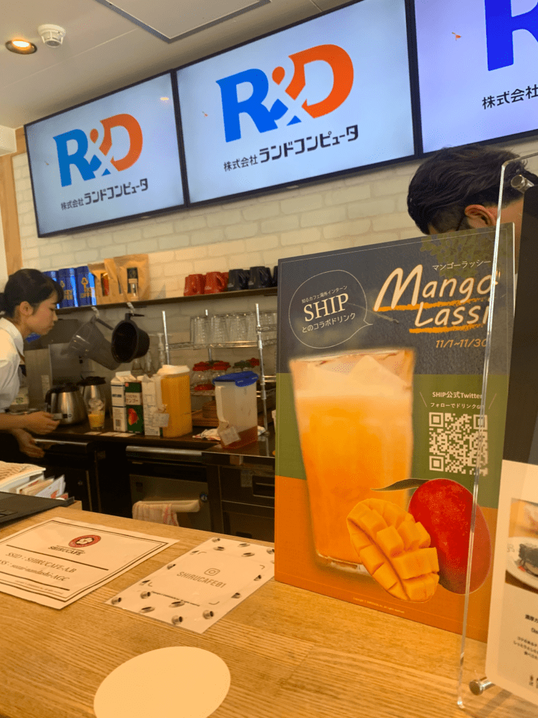 The counter of Shiru Cafe, with a sign dvertising a mango drink